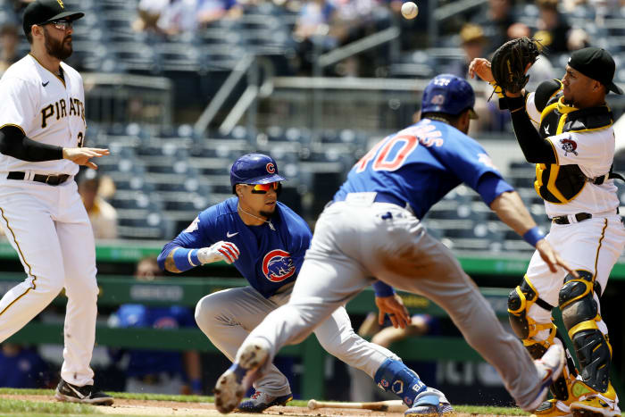 May 27, 2021; Pittsburgh, Pennsylvania, USA; Pittsburgh Pirates first baseman Will Craig (left) chases Chicago Cubs shortstop Javier Baez (9) in a run-down between home plate and first base allowing catcher Willson Contreras (40) to score a run as Pirates catcher Michael Perez (right) takes a throw during the third inning at PNC Park.